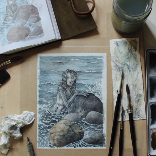 Akvarelmaleri af havfrue hvilende på en sten. Originalen sælges på messen. 
